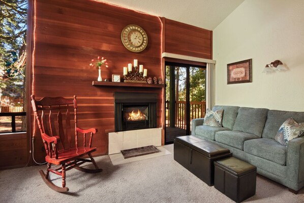 Studio living room with Smart TV, gas fireplace, dining area & balcony access