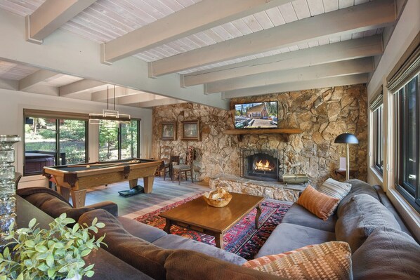 Cozy and spacious living area with Pool Table, TV, and Fireplace