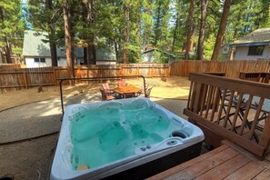 Backyard with private outdoor hot tub, BBQ, and patio seating