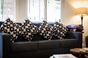 Living room with Roku TV, wood burning fireplace and comfortable seating