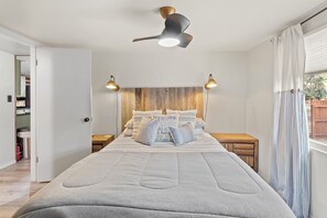A beautifully decorated primary bedroom with a queen bed & rustic-inspired decor
