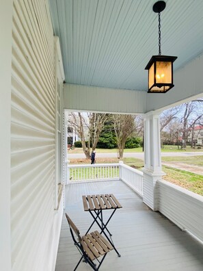 Wrap-around porch with 'haint blue' ceiling, a Southern tradition.