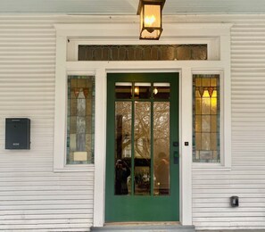 Front door with leaded glass panes and two stained glass panels.