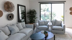 Living area with sofa bed and access to two outdoor courtyards.