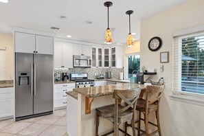 Fully-stocked kitchen with bar stools