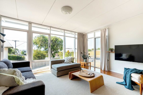 The open plan living area captures abundant natural light, creating a warm and cheerful hub with ocean views