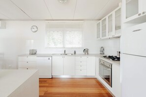 The light-filled kitchen offers everything you need, from modern appliances to a coffee plunger, blending rustic charm with convenience