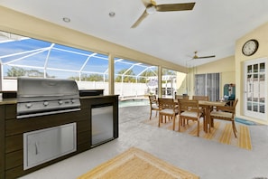 Grill out on the outdoor kitchen BBQ while the kids play in the pool and enjoy a meal under the shade at the dining table.