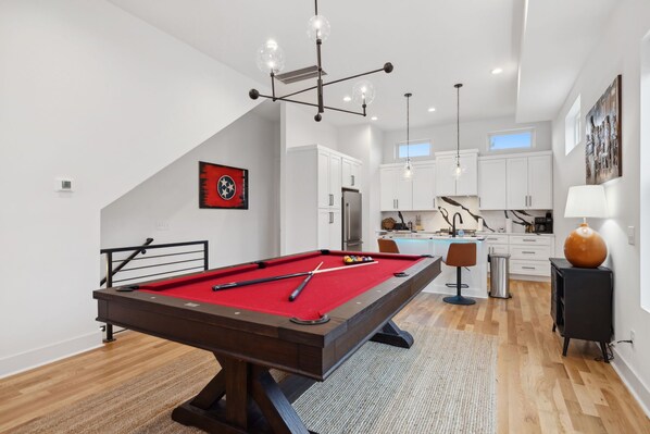 Living Room: This inviting space includes a red pool table, large sectional, and modern design elements for the perfect mix of fun and comfort.