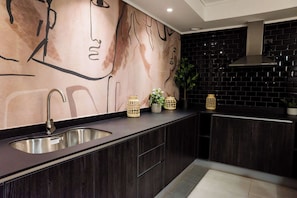 Experience culinary creativity in this stylish kitchen with unique art and modern finishes.