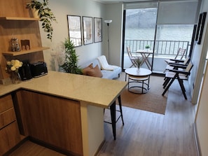 Relax in this cozy living area with a charming balcony view, perfect for enjoying your morning coffee.