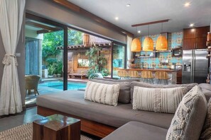 Open-plan kitchen and living room with a modern and trendy design. Beautiful windows that provide access to the patio.