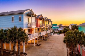 Golden hour magic transforms these whimsical beach cottages into a postcard-perfect escape! The breathtaking sunset paints the sky in mesmerizing hues, casting a warm glow over your private coastal hideaway.