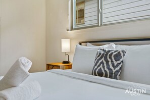 Soft pillows, crisp luxury linens, and a glow from the bedside lamp—your perfect wind-down spot!