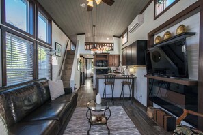 An inviting living space with vaulted ceilings and natural light pouring through the tall windows.