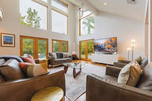 Living room with electric fireplace and  multiple doors leading to the deck. 