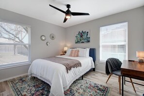 Primary bedroom with desk and TV