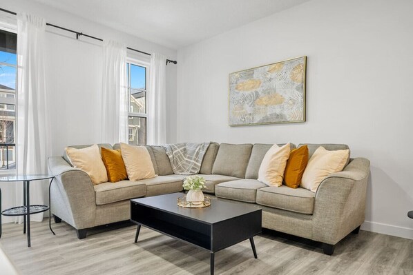 Living room with a 65" Smart TV and cozy seating options.