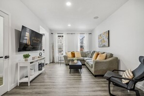 Living room with a 65" Smart TV and cozy seating options.