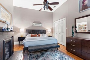 The primary bedroom features a plush bed, a smart TV, and timeless charm.
