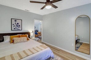 Rest and recharge in the primary bedroom, featuring a plush queen bed and a dedicated workspace for your convenience.