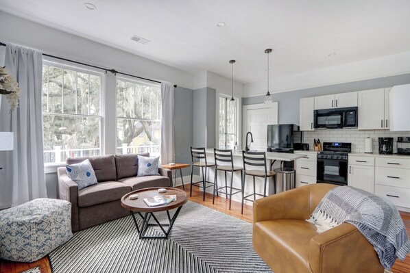 Bright and inviting, the open living room features large windows that fill the space with natural light.