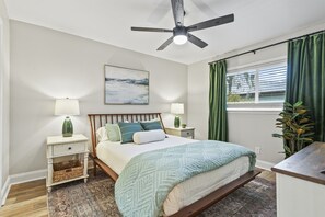 Relax in the spacious primary bedroom featuring an ensuite bath and a smart TV—perfect for unwinding in comfort and style.