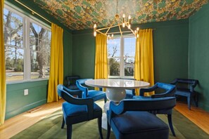 This vibrant green dining room with a wallpapered ceiling is where elegance meets whimsy—because every meal deserves a magical backdrop!