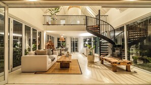 Spacious living area with a gentle spiral staircase leading to the bedroom