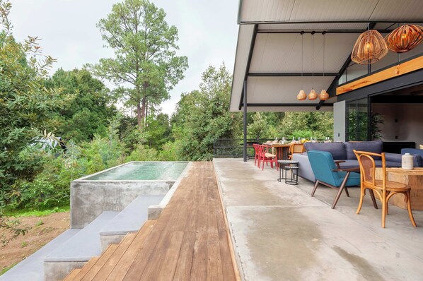 Terraza con alberca privada y vista la jardín 

