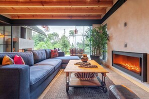 Sala de estar con chimenea y vista al jardín 