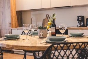 The wooden dining table is the heart of the apartment—perfect for fresh fruit, family dinners, and board games. Evenings here take on a special charm, fostering connection and joy.