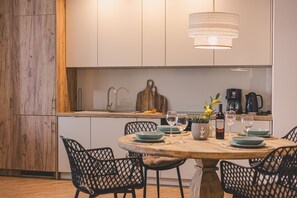 The wooden dining table is the heart of the apartment—perfect for fresh fruit, family dinners, and board games. Evenings here take on a special charm, fostering connection and joy.