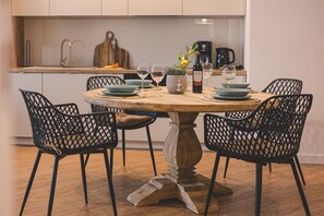 The wooden dining table is the heart of the apartment—perfect for fresh fruit, family dinners, and board games. Evenings here take on a special charm, fostering connection and joy.