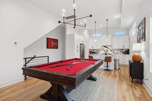 Living Room: This inviting space includes a red pool table, large sectional, and modern design elements for the perfect mix of fun and comfort.