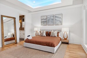 Bedroom 1: This modern bedroom features a backlit ceiling, large windows, and a cozy sitting area, ideal for relaxation. 