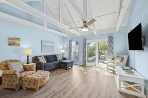 Bright living space with ample seating, deck access, and TV