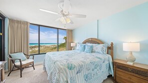 Wake up to stunning Gulf views in this bright and breezy beachfront bedroom, featuring a cozy king-sized bed with sea-themed bedding. Natural light floods the room through floor-to-ceiling windows, perfectly framing the white sand dunes and turquoise wate