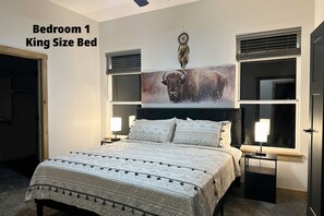 The spacious king bedroom has a smart TV, couple books and ceiling fan.