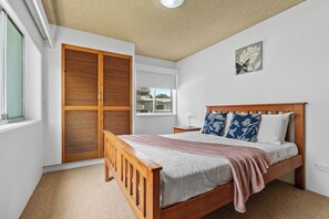 Wake up in the primary queen bedroom to soft natural light and glimpses of the ocean beyond.