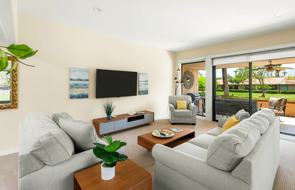 Bright and stylish living room with a gray couch, natural wood furniture, and smart entertainment.