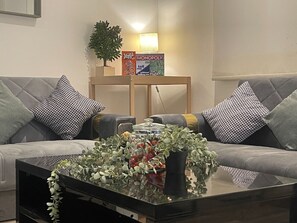 A bright and airy living room with high ceilings, soft textiles, and a comfortable sectional sofa, ideal for relaxation and family gatherings.