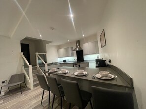 A stylish dining area featuring a large wooden table, chic chairs, and a statement chandelier that sets the perfect ambiance for meals.