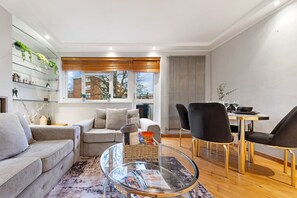 Spacious living area with cosy furnishings, ideal for unwinding in style.