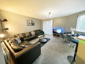 "Relax in style! This inviting living space features plush seating, a flat-screen TV, and a charming dining table, perfect for meals and gatherings, all within a cozy ambiance."