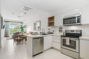 Cook with ease in this modern, fully equipped kitchen featuring stainless steel appliances - Open layout flows seamlessly into the dining & living area, perfect for gathering - Bright & functional, this space makes every meal feel like home