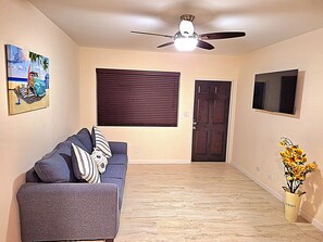 Front room with smart TV and couch with queen size bed