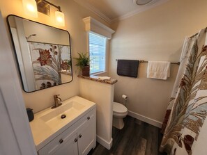Elegant fixtures and sunlight dance in this serene sanctuary. Indulge and refresh!