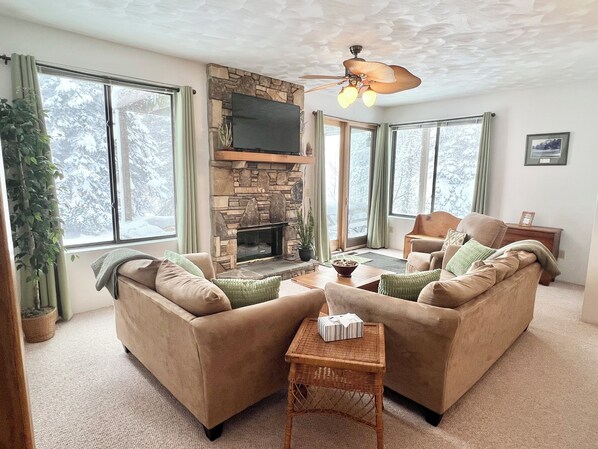 Bright living room with door to deck, offering 1st level access to North Summit!