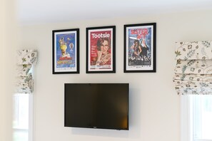 This chic king bedroom features a Smart TV & fantastic theater artwork